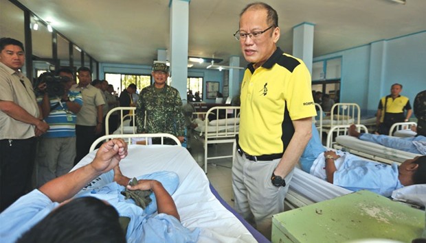 Handout photo released by Malacanang Photo Bureau (MPB) yesterday shows Philippine President Benigno Aquino talking to one of the wounded soldiers who recently clashed with Abu Sayyaf militants, during a visit to a military hospital in Zamboanga City on southern island of Mindanao.