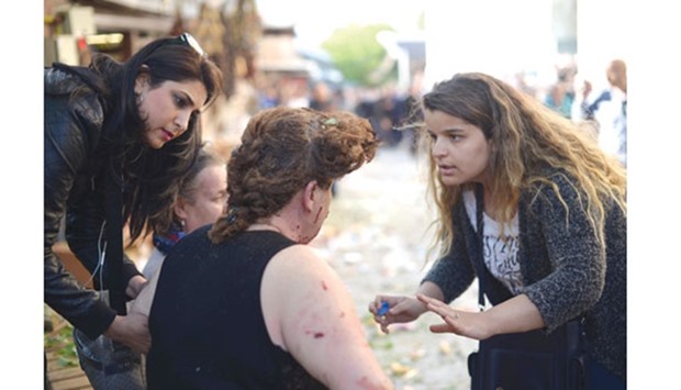 A woman gives first aid to an injured woman following a suicide bombing in Bursa.