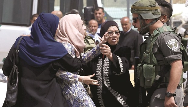 A Palestinian woman argues with an Israeli border policeman near the scene where a Palestinian woman and a man were shot dead by Israeli police near Qalandia checkpoint.