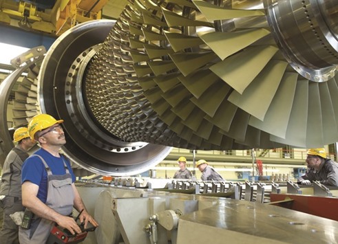 Siemens employees in the final assembly hall of the Berlin manufacturing plant while inserting a turbine rotor of the Siemens gas turbine SGT5-4000F.