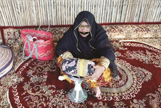 An Emirati woman makes a handmade pillow at the Heritage Village in Dubai.
