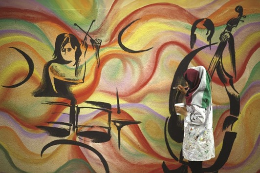 An artist paints murals on the walls of a school run by the UN Relief and Works Agency for Palestine refugees in Gaza City.