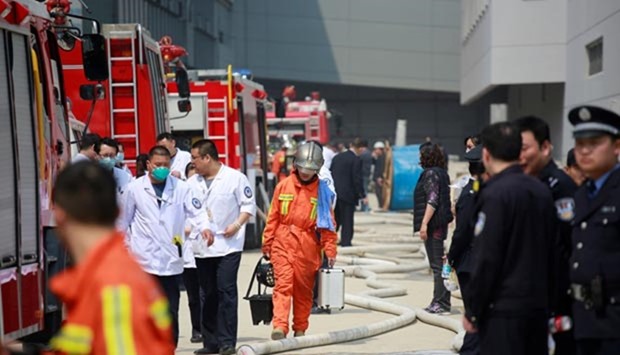 Firefighters and police are seen near the site of a fire at the Shanghai Hongqiao Airport in Shanghai on Friday.