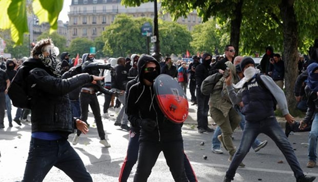 Masked youths face off with police during a demonstration against the French labour law proposal in Paris.