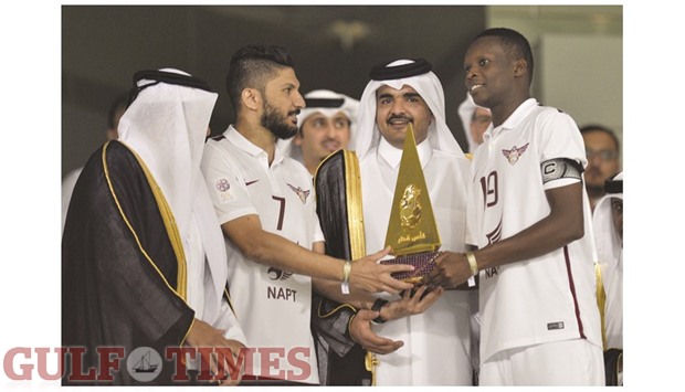 Qatar Olympic Committee chief HE Sheikh Joaan bin Hamad  al-Thani presenting the 2016 Qatar Cup trophy to El Jaish players Wesam Rizik, left, and Abdurahman Mohamed at the Al Sadd stadium yesterday. El Jaish scored through Mohamed Methnani and Abderrazaq Hamedallah while Lekhwiyau2019s only goal was scored by Alain Dioko. With yesterdayu2019s win, El Jaish exacted revenge over Lekhwiya who had beaten them in last yearu2019s final.   PICTURE: Noushad Thekkayil
