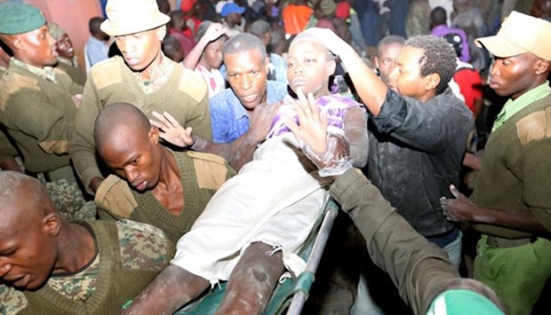 Kenyan security forces and emergency personnel carry a survivor rescued from a collapsed building in Nairobi.