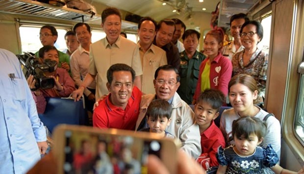 Cambodian Prime minister Hun Sen (centre) poses with passengers on a train at the Phnom Penh station on Saturday.