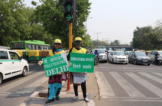 Civil defence volunteers stand on a Delhi street with placards during the final day of the second phase of the odd-even traffic scheme yesterday.