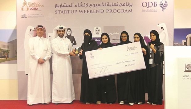 Members of the winning team of QDBu2019s u201cStartup Weekend Dohau201d programme receive the prize.
