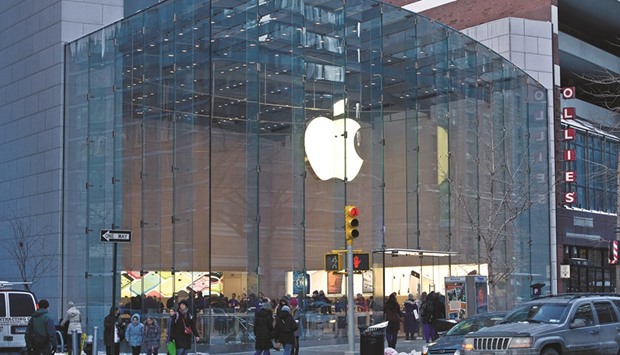 Pedestrians pass in front of an Apple store in New York. Disappointing sales forecasts from technology giants including Apple and Microsoft Corp have led to deep losses among makers of everything from software to computers and the components that make them work.