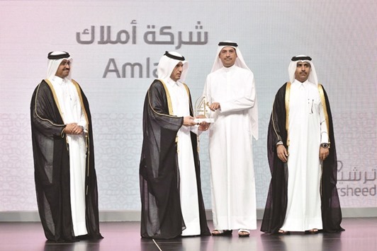 HE Sheikh Abdullah presenting the certificate to al-Emadi. Also present are HE Dr al-Sada and al-Kuwari.
