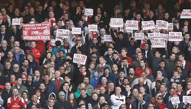Hundreds of Arsenal fans hold up posters bearing the words u2018TIME FOR CHANGEu2019 during the teamu2019s Premier League match Norwich City at the Emirates Stadium yesterday, venting their frustration at Arsenalu2019s 12-year league title drought under long-serving Frenchman Arsene Wenger. Arsenal won the match 1-0 to keep their top-four chances alive. (Reuters)
