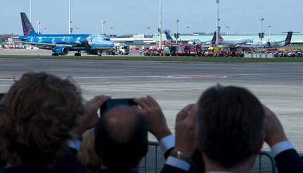People take pictures while the first plane takes off from Brussels Airport in Zaventem on Sunday.