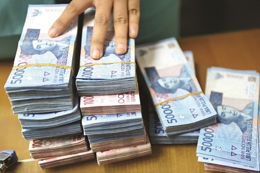 Bundles of Indonesian rupiah banknotes are seen on a desk at a currency exchange office in Jakarta. While the rising rupiah is good for Indonesian holidaymakers, it inflates the cost of the nationu2019s exports and makes imports more affordable, disrupting efforts to rein in the current-account deficit.
