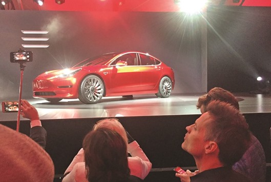 A Tesla Model 3 sedan, its first car aimed at the mass market, is displayed during its launch in Hawthorne, California, on March 31. The $35,000 Model 3 will have a minimum 215 miles (346km) range, and deliveries are expected to begin next year.