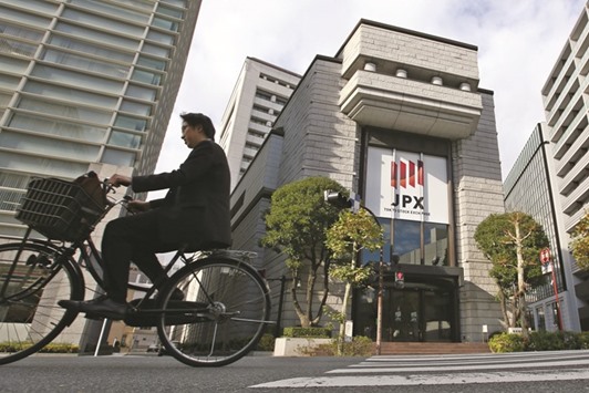 A man cycles past the Tokyo Stock Exchange. A move by the Bank of Japan to adopt negative interest rates sparked a selloff in financial shares, sending Tokyo stocks deeper into a bear market.