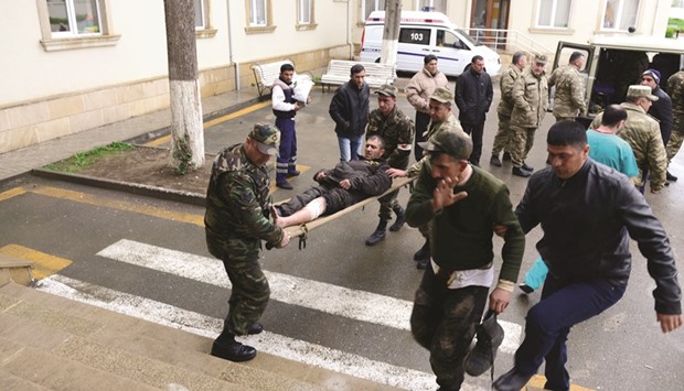 Azeri servicemen bring their comrade, who was wounded during clashes with Armenian forces in Armenian-seized Azerbaijani region of Nagorno-Karabakh, to a hospital in the town of Terter.