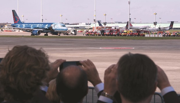 People take pictures while the first plane takes off from Brussels Airport.