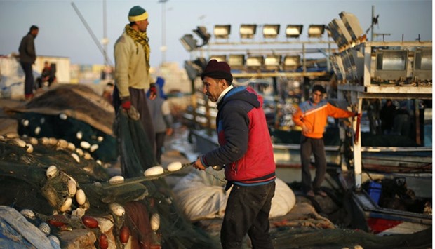 Palestinian fishermen clean their net after taking fish out of it at the Seaport of Gaza City. Reuters