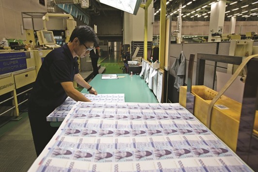 An employee inspects sheets of won banknote at the Korea Minting, Security Printing & ID Card Operating Corp factory in South Korea. The won led the March rally with an 8.2% advance and Malaysiau2019s ringgitu2019s 7.8% jump was its biggest since 1998.