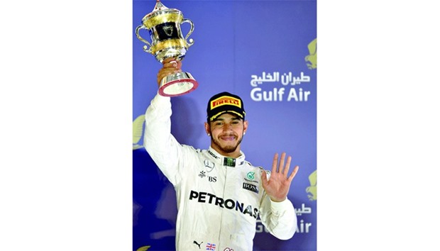 Third placed Mercedes AMG Petronas F1 Teamu2019s British driver Lewis Hamilton holds up his trophy on the podium after the Bahrain Formula One Grand Prix at the Sakhir circuit in Manama. (AFP)