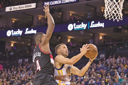 Golden State Warriors guard Stephen Curry (R) shoots the basketball against Portland Trail Blazers forward Maurice Harkless during the fourth quarter at Oracle Arena. PICTURE: USA TODAY Sports