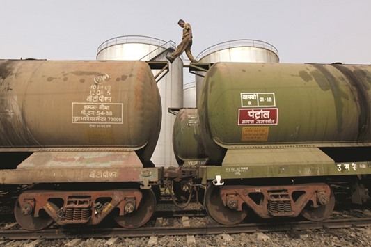 A worker walks atop a tanker wagon to check the freight level at an oil terminal on the outskirts of Kolkata. Indian Oil Corporation aims to buy 80,000 bpd from Iran with an option for another 40,000 bpd.