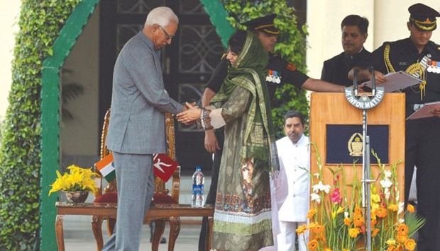 Mehbooba Mufti shakes hands with Jammu and Kashmir Governor N N Vohra after taking oath during her swearing-in ceremony in Jammu yesterday.