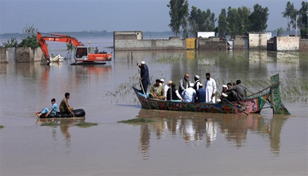 Residents use boats and inner tubes to float around in floodwater after heavy rain in Peshawar