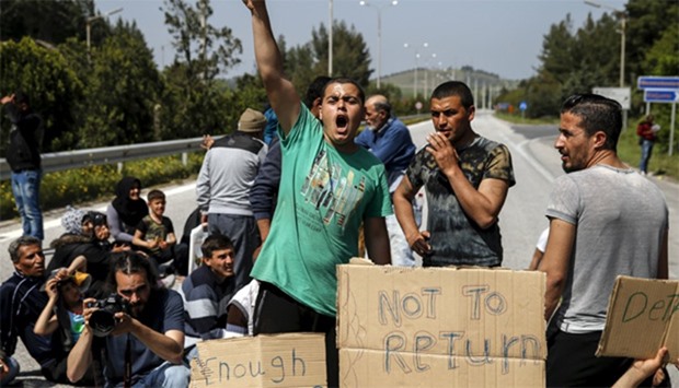 Migrants and refugees shout slogans