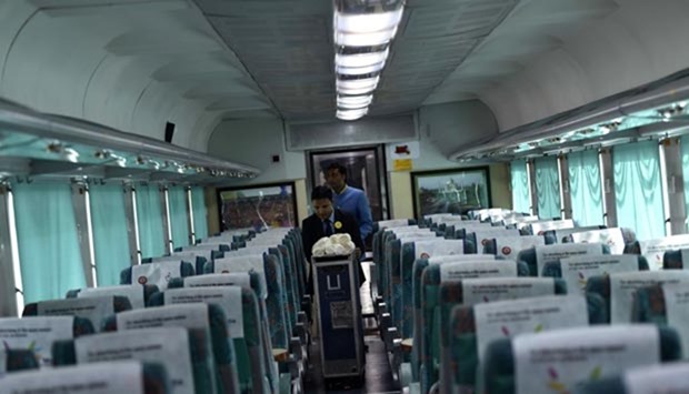 Indian Railways staff push a trolley inside a carriage of the 'Gatimaan Express' train in New Delhi on Tuesday.