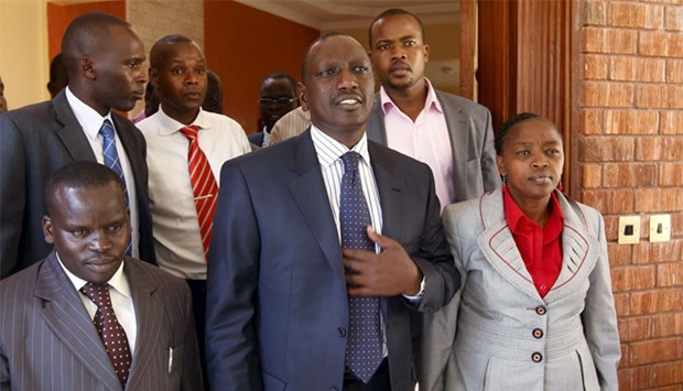 Former Kenyan cabinet minister William Ruto (C) stands next to his wife Rachel (R) and Kenyan radio presenter Joshua Arap Sang (L) in Ruto's house after hearing the news from the International Criminal Court in Nairobi. File photo, January 23, 2012