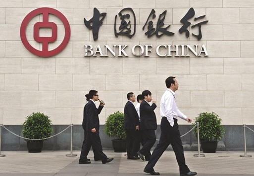 Pedestrians walk past a Bank of China branch in Beijing. Bad debt in Chinau2019s banking industry jumped 51% last year to 1.27tn yuan, data from the banking regulator showed yesterday.