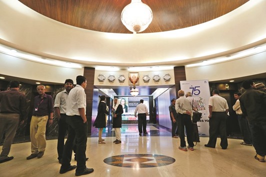 Employees walk in the lobby of the Bombay Stock Exchange building in Mumbai. The Sensex closed down 2% yesterday, the steepest decline since February 11.