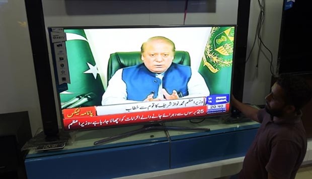 Pakistani people watch a televised address to the nation by Nawaz Sharif in Islamabad.