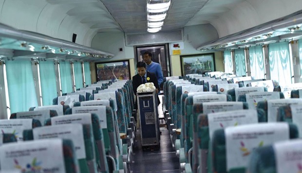 Railways staff push a trolley inside a carriage of the Gatimaan Express train in New Delhi yesterday.