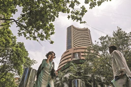 Pedestrians walk past the Bombay Stock Exchange in Mumbai. The benchmark S&P BSE Sensex closed up 17 points to 24,900.63 yesterday.