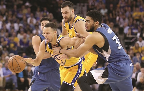 Stephen Curry (No 30) of the Golden State Warriors tries to dribble between Ricky Rubio and Karl-Anthony Towns (R) of the Minnesota Timberwolves at ORACLE Arena in Oakland, California. (Getty Images/AFP)