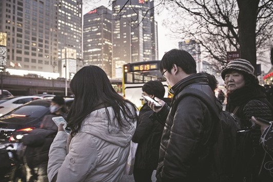 Commuters using smartphones stand in line at a bus station in Beijing. Fears about Chinau2019s slowdown may be overstated, while lower commodity prices could actually help net importers including China and India, the two biggest emerging economies, according to Capital Group.