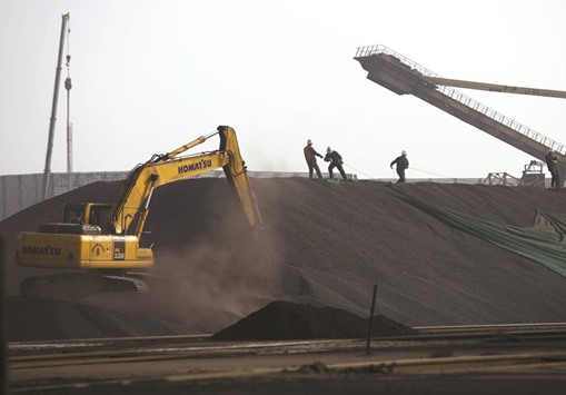 Labourers work on a pile of iron ore at a steel factory in China. Stockpiles held at Chinau2019s ports may soon expand to breach 100mn metric tonnes for the first time in a year as supplies increase, potentially weighing on prices.