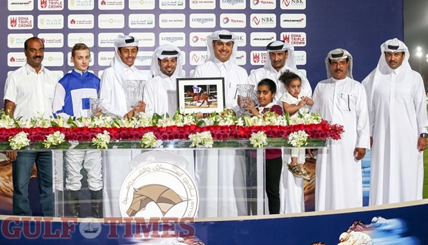 Fahad Ali al-Kaabi (fourth from left) with the winners of the Mesaimeer Cup at the Qatar Racing and Equestrian Club here yesterday. Jockey Harry Bentley (second from left) rode Third Dimension, owned by Khalifa bin Sheail al-Kuwari and trained by Jassim Ghazali (fifth from left), to victory in the thoroughbred conditions race yesterday. PICTURES: Juhaim