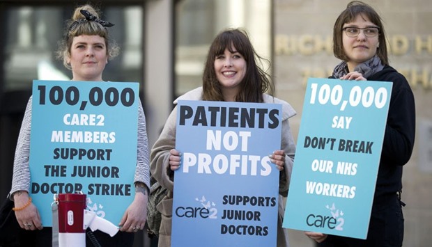 Demonstrators hold placards during a protest by striking junior doctors outside the department of health in central London yesterday.
