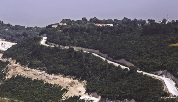 A general view shows the area (left and bottom) where the Israeli army is excavating part of a cliff to create an additional barrier along its border with Lebanon, as houses in Kibbutz Hanita are seen on the hilltop, near the community of Shlomi in northern Israel. Israeli Defence Forces (IDF) Lieutenant-General Eli David, who serves as an engineering officer in a northern division, said yesterday that the army began work on the new barrier by exposing the cliff in January 2015, to help protect communities located close to the Lebanese border from infiltrators.