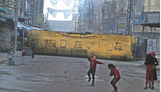 Children playing near a bus barricading a street, which serves as protection from snipers loyal to the Syrian regime, in Aleppou2019s opposition-controlled Bustan al-Qasr neighbourhood, yesterday. Fighting south of Aleppo in recent days has put further strain on the already widely violated ceasefire deal brokered by the United States and Russia with the aim of launching a diplomatic process towards ending the five-year-long war.