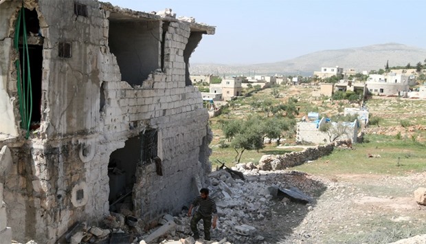A man inspects damaged buildings in Idlib, Syria