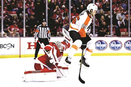 Detroit Red Wings goalie Jimmy Howard (left) makes the save behind the screen of Philadelphia Flyers center Ryan White during their NHL game in Detroit, Michigan, on Wednesday. (USA TODAY Sports)