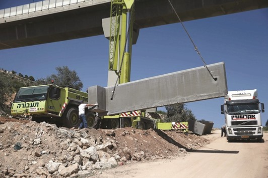 Israeli workers place a new section of the separation concrete barrier in the Cremisan Valley, adjacent to the Christian Palestinian town of Beit Jala, in the Israeli-occupied West Bank.