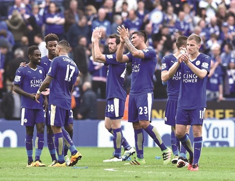 Leicester Cityu2019s Austrian defender Christian Fuchs (C) and Leicester Cityu2019s Argentinian striker Leonardo Ulloa applaud fans after winning the English Premier League match against Southampton at King Power Stadium in Leicester on April 3. (AFP)
