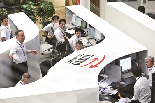 Employees work at the Tokyo Stock Exchange. The Nikkei 225 closed up 0.5% to 15,821,52 points yesterday.