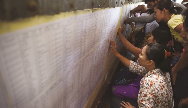 Relatives check lists of prisoners due for release yesterday at Insein prison in Yangon.